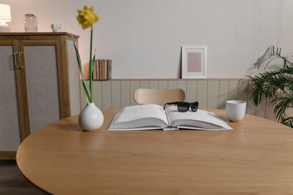Botanisches Bestimmungsbuch mit gepressten Pflanzen auf einem Holztisch